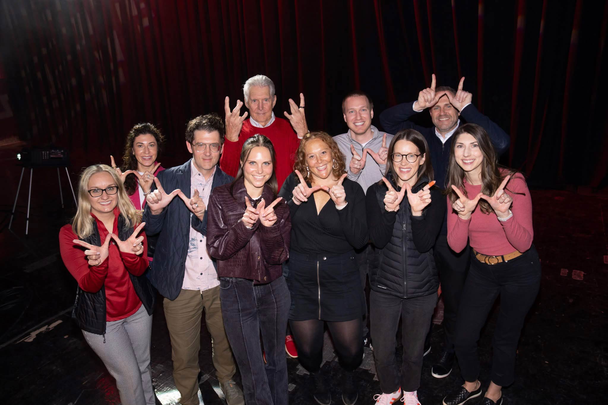 A group of Exact Sciences employees posing together holding up the letter W with their fingers for the University of Wisconsin